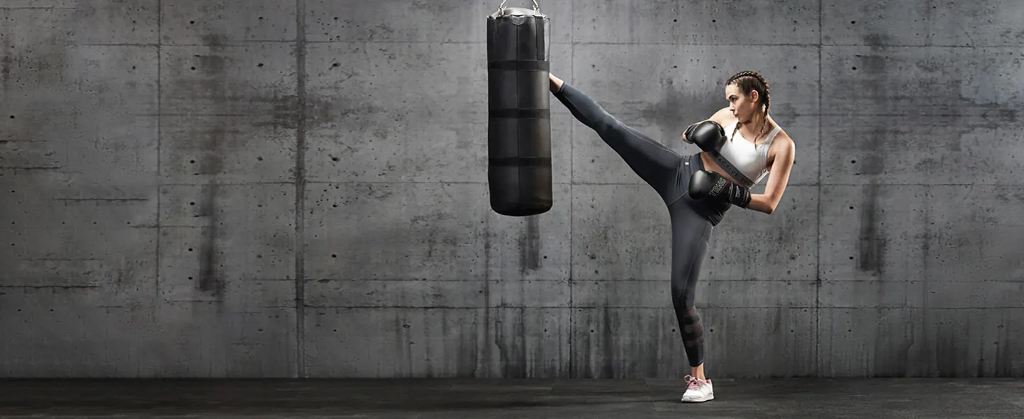 A woman kicking a punching bag