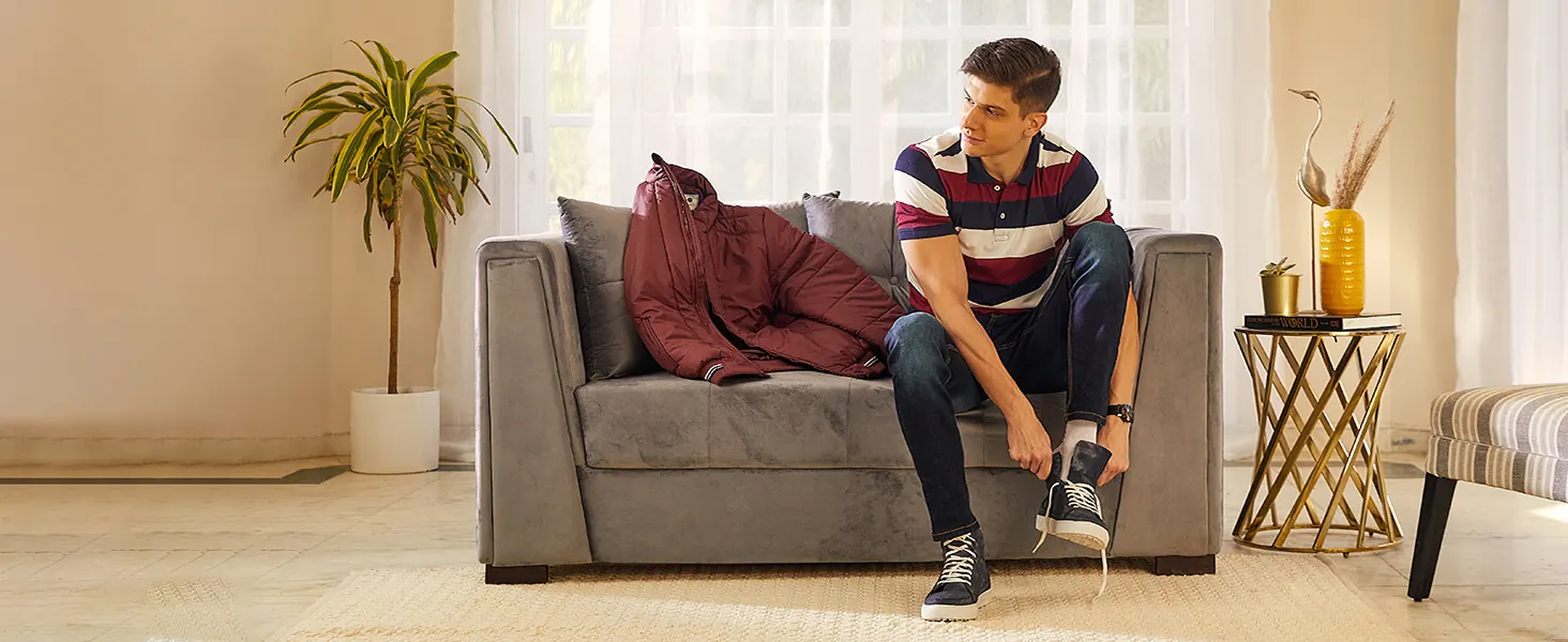 A man in a striped polo shirt on a sofa