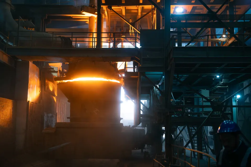 An orange glow among the steel structures of a dark plant