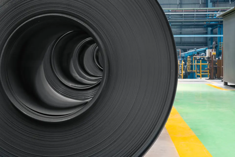 Looking into the middle of a black steel coil, its layers spiralling inwards