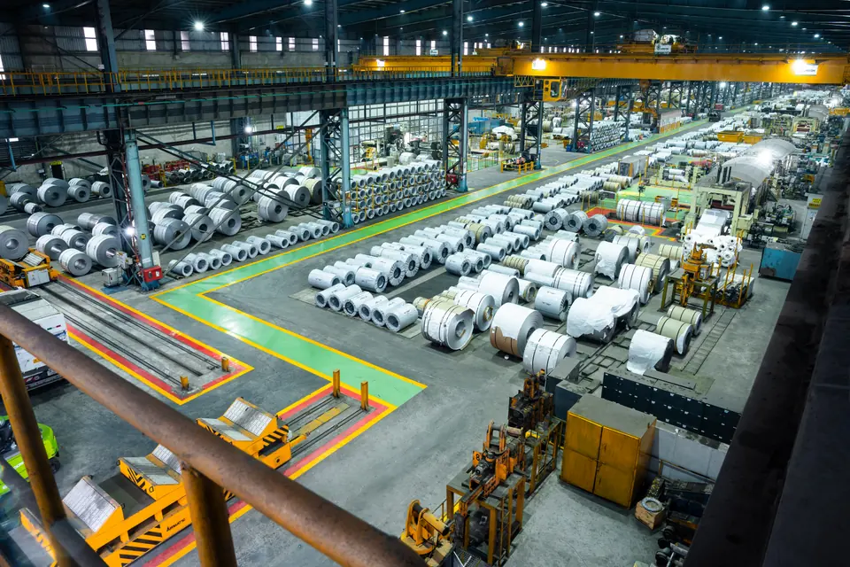 Rows of bright steel coils across a green and yellow floor, seen from above