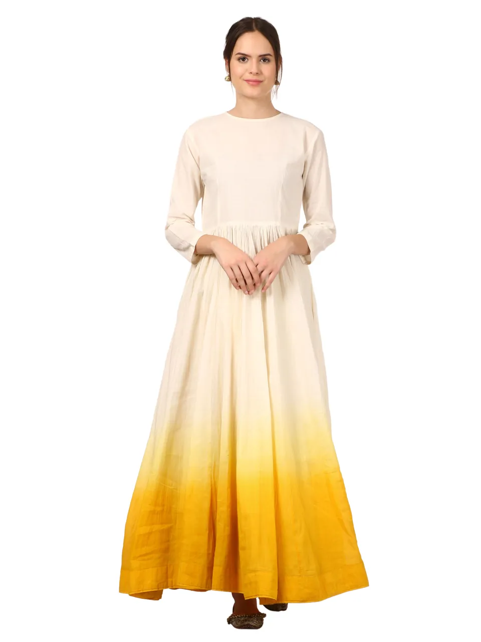 Front view of a model in a cream anarkali that fades to mustard yellow at the hem, on white