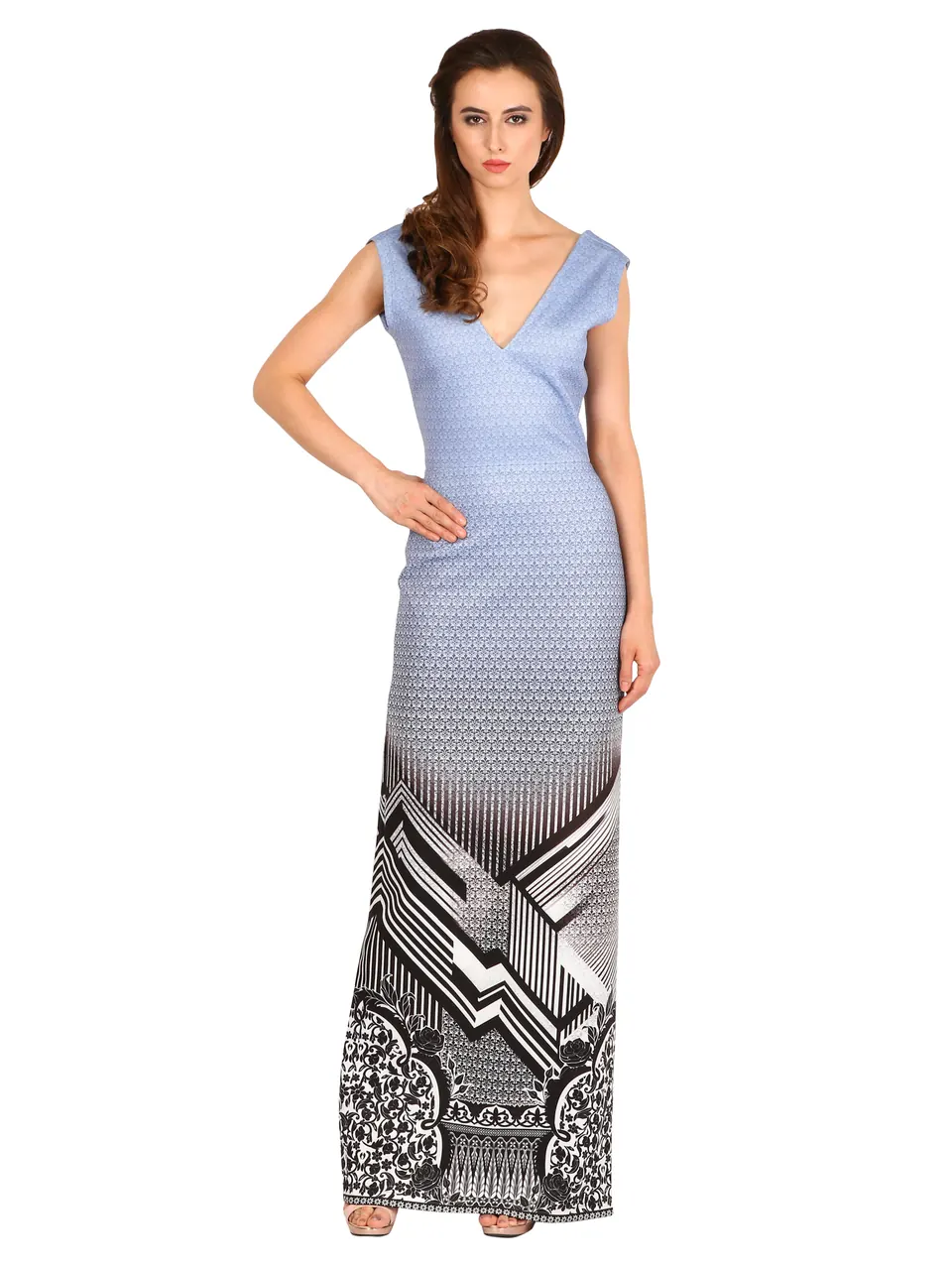 A model in a blue V-neck column dress with a geometric print at the hem, on white