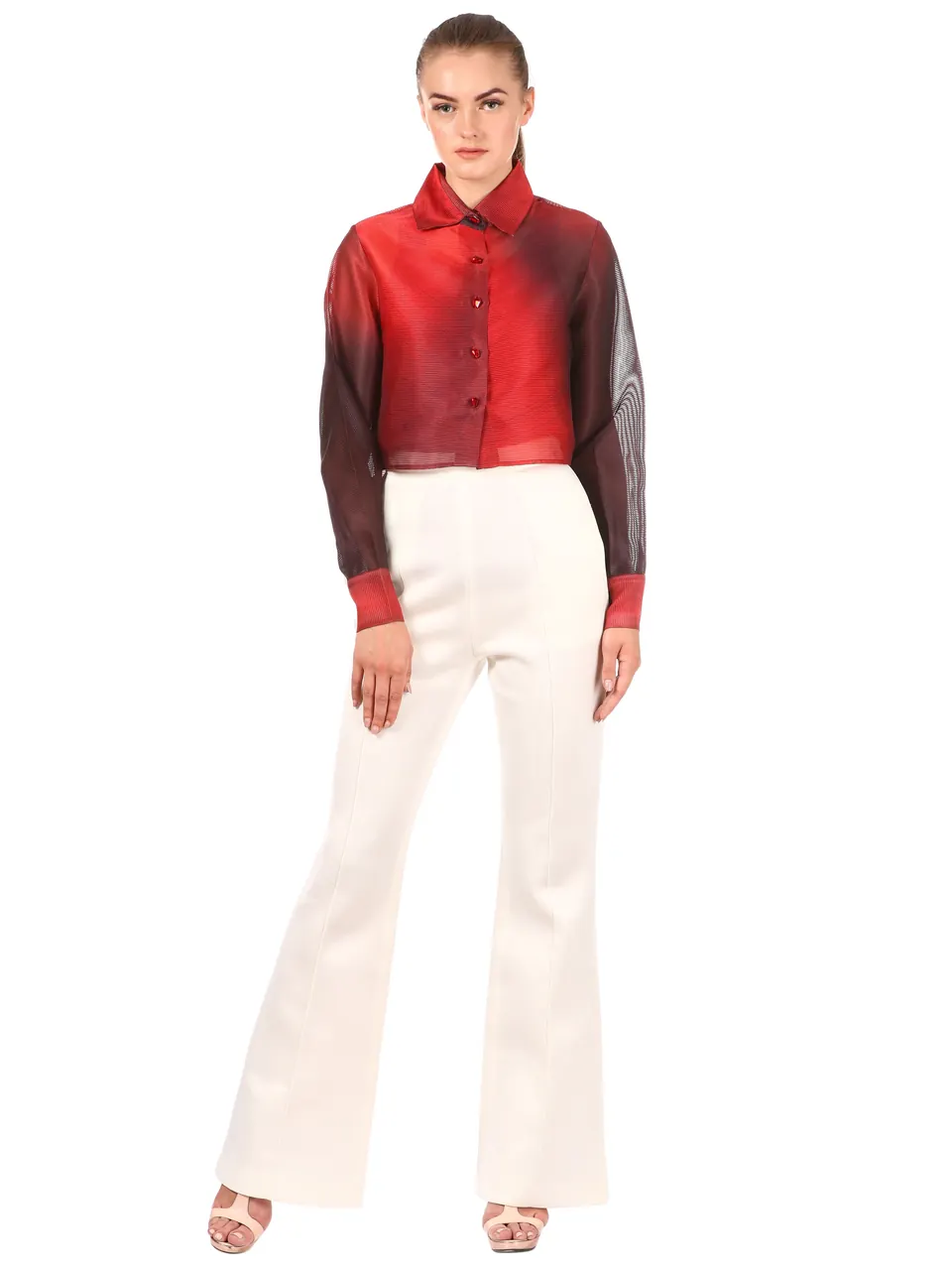 A model in a red ombré shirt and white flared trousers, on white