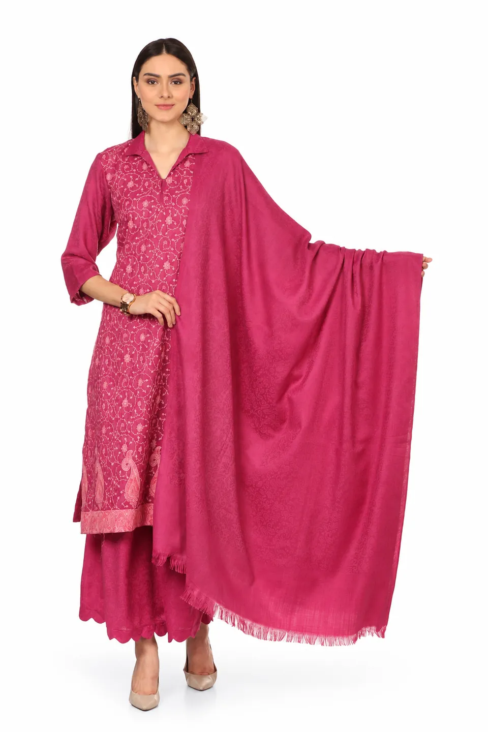 A model in a magenta kurta set with fine embroidery and a paisley border, holding out a matching stole, on white