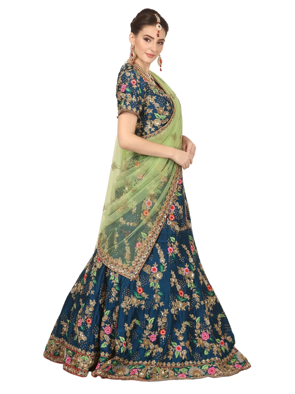 A model in an embroidered navy lehenga with a sheer green dupatta, on white