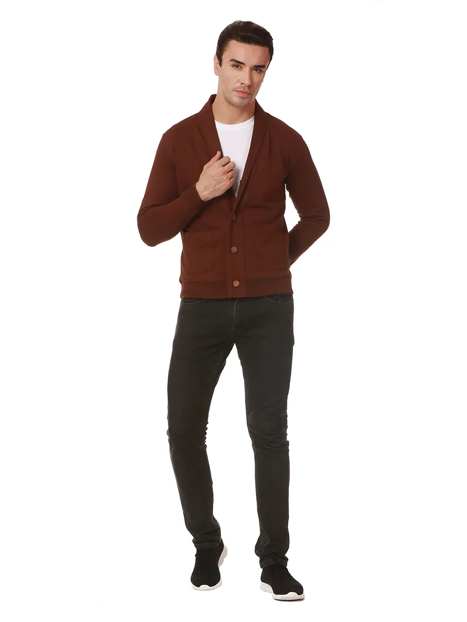 A male model in a brown cardigan and black jeans, shot full length on white