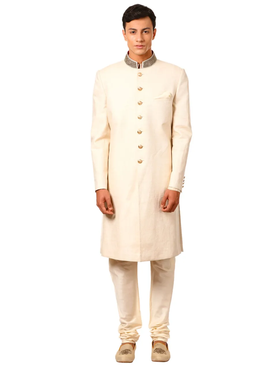 A male model in a cream sherwani with an embroidered collar, on white