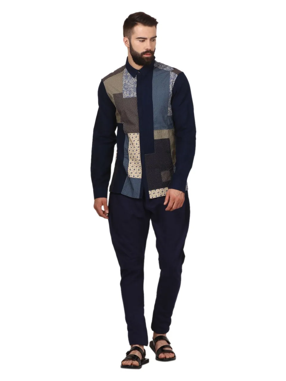 A male model in a navy patchwork shirt, on white
