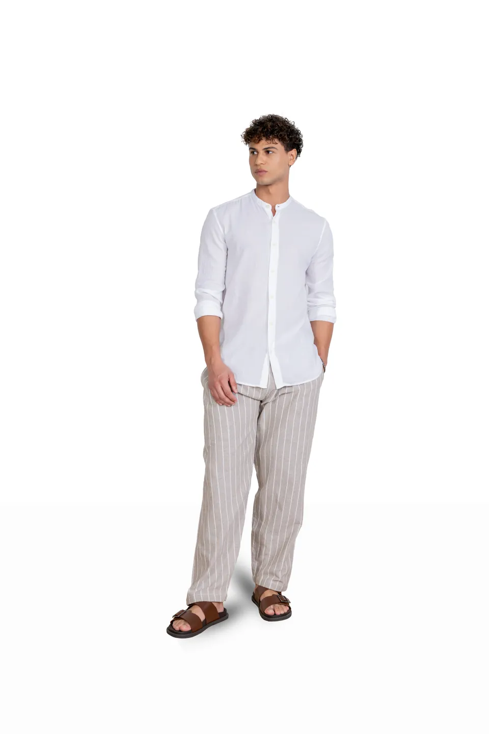A male model in a white shirt and striped trousers, shot full length on white