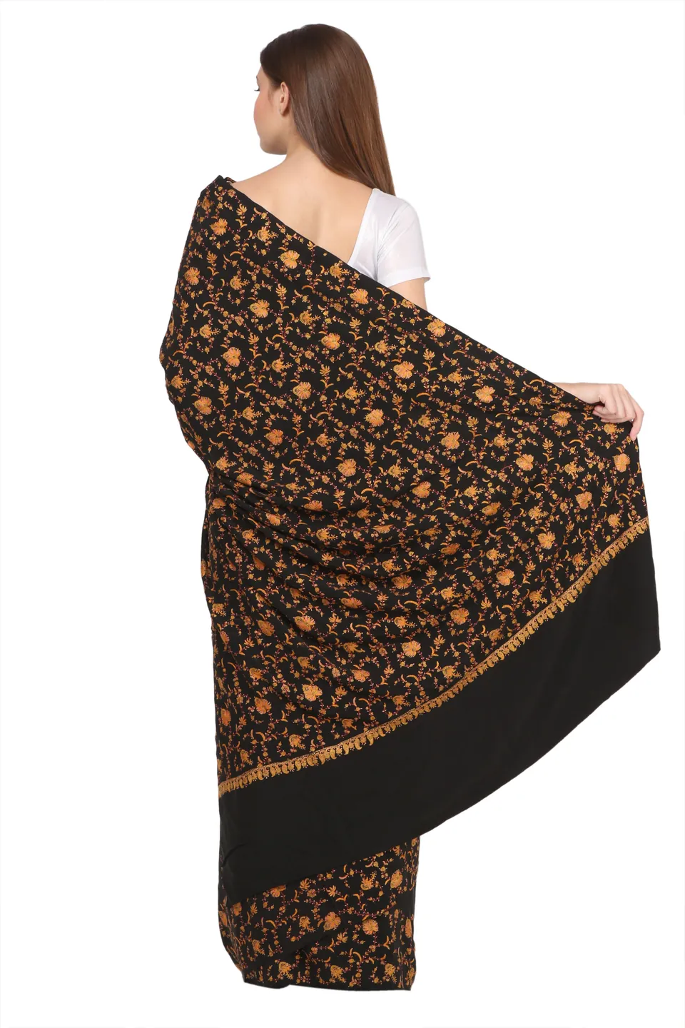 A model seen from the back, holding open the pallu of a black saree with all-over floral embroidery, on white