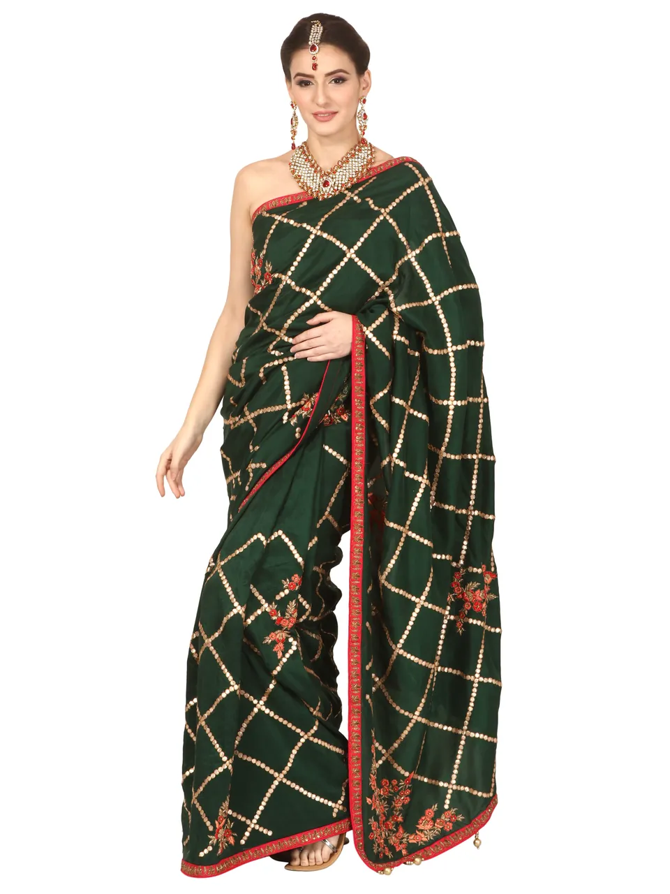 A model in a dark green saree with gold checks and floral embroidery, with bridal jewellery, on white