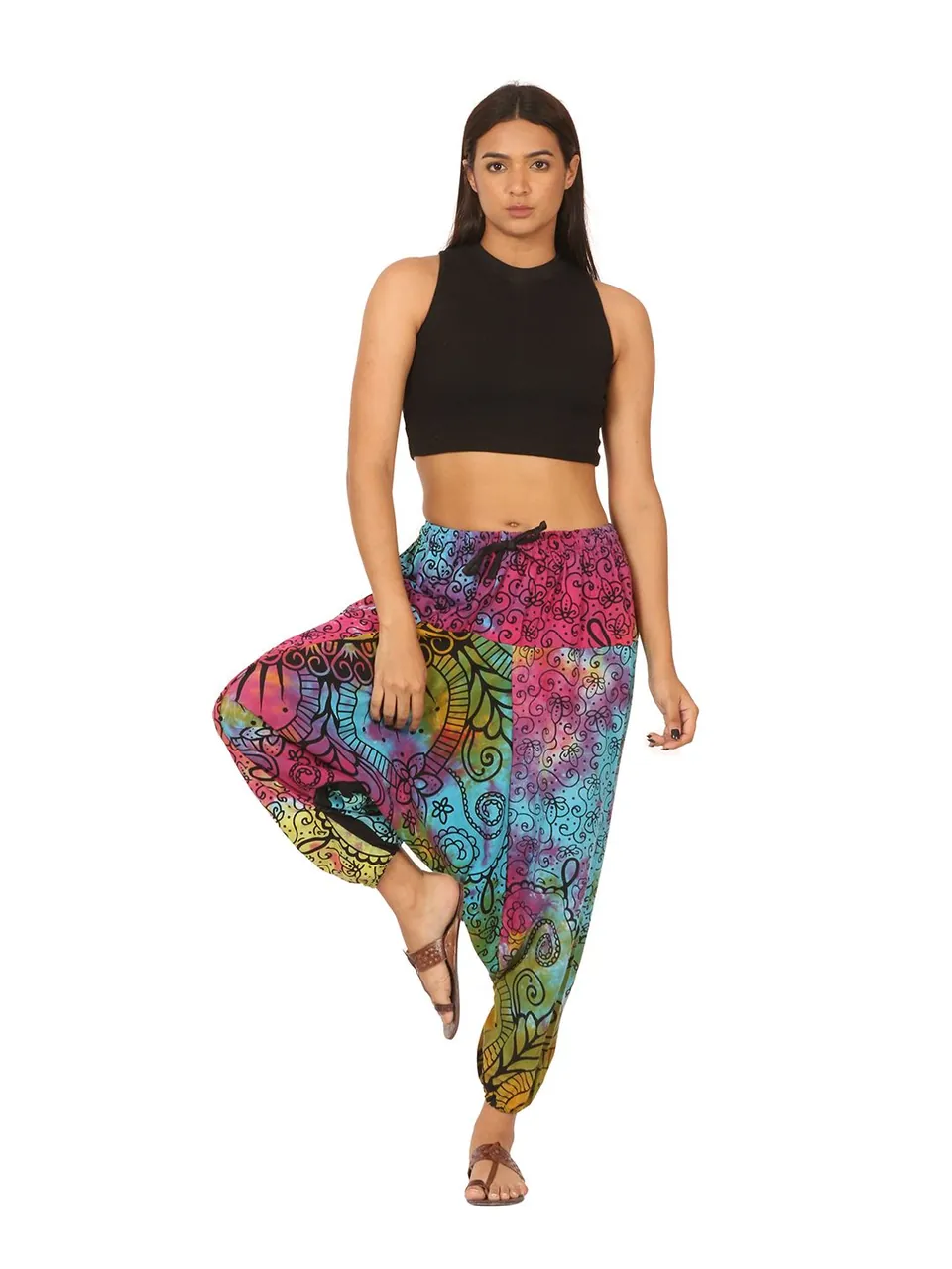 A model in a black crop top and colourful mandala-print harem pants, on white