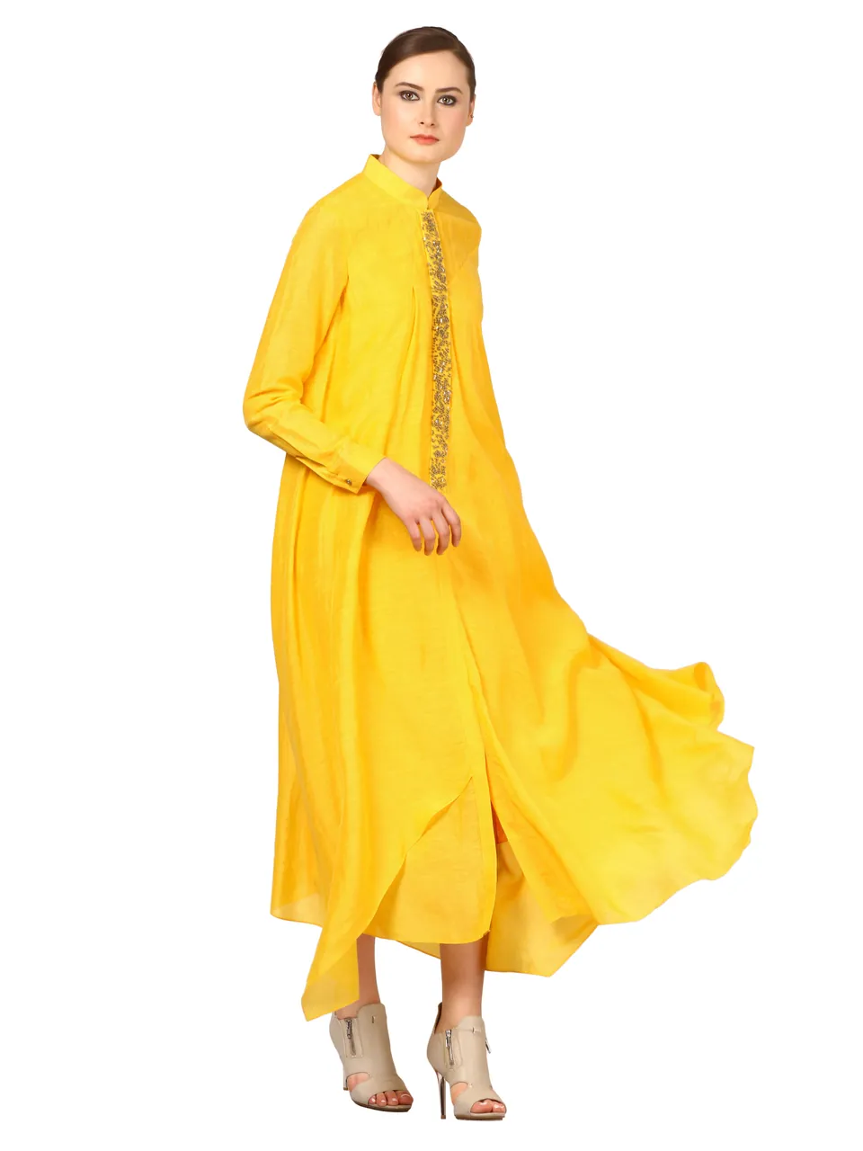 A model in a yellow shirt dress, its hem flaring as she moves, on white